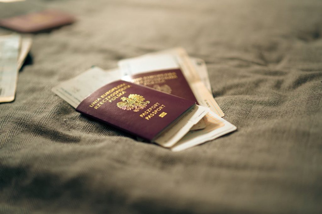 Polish Passport and Travel Documents on Bed Surface