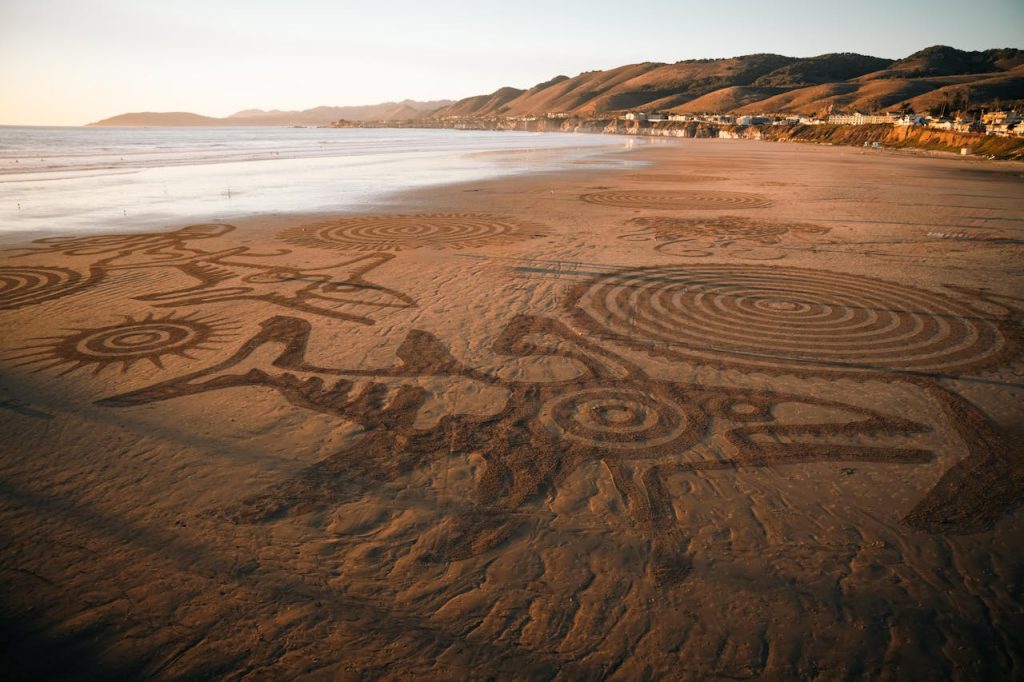 Intricate Sand Art on Coastal Beach at Sunset