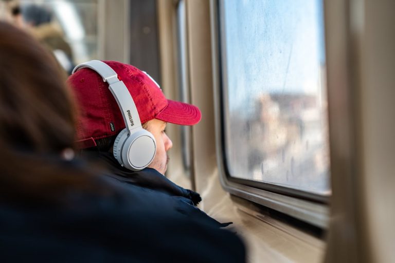 Man on Train with Headphones Looking Out