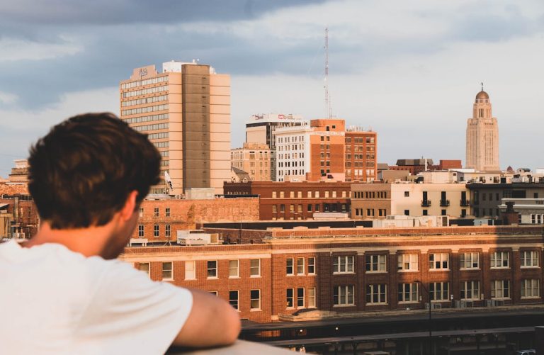 Boy in White Crew-neck T-shirt Looking on Building