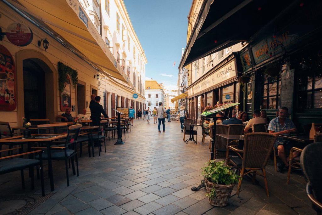 A pedestrian-only street with cafés and people strolling.