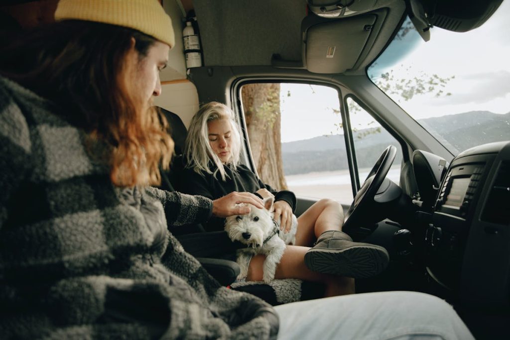 Man and Woman Sitting Inside the Campervan with Their Dog