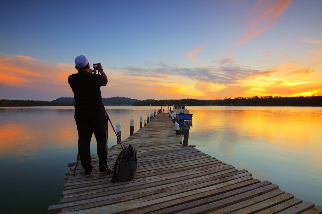 A wooden dock extending into calm water at sunset
