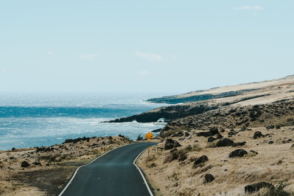 Empty road along rocky coastline near sea 