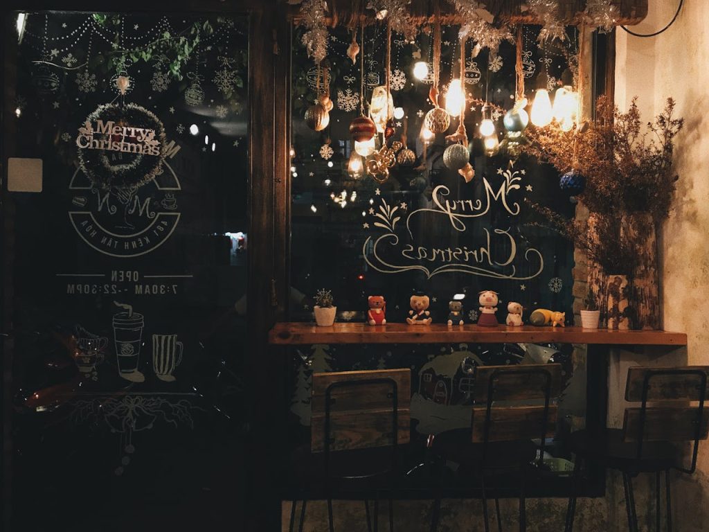 A classic store front trimmed with wreaths and soft golden light.
