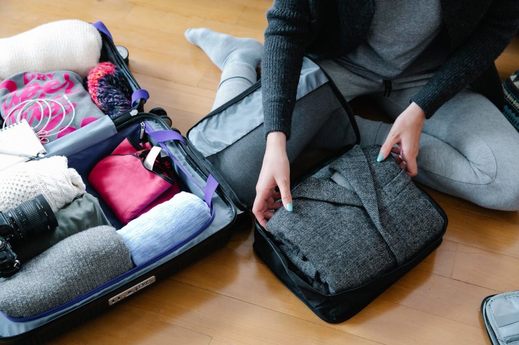 A suitcase mid-pack with rolled clothes along the edges and heavier items placed at the base.