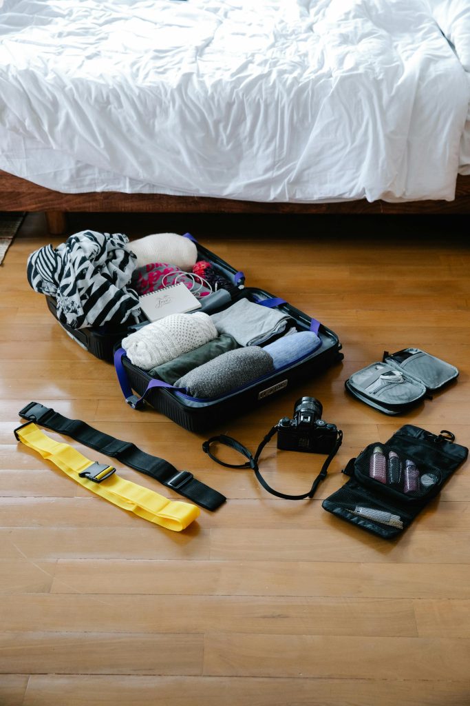 Luggage and Travel Essentials on a Wooden Floor