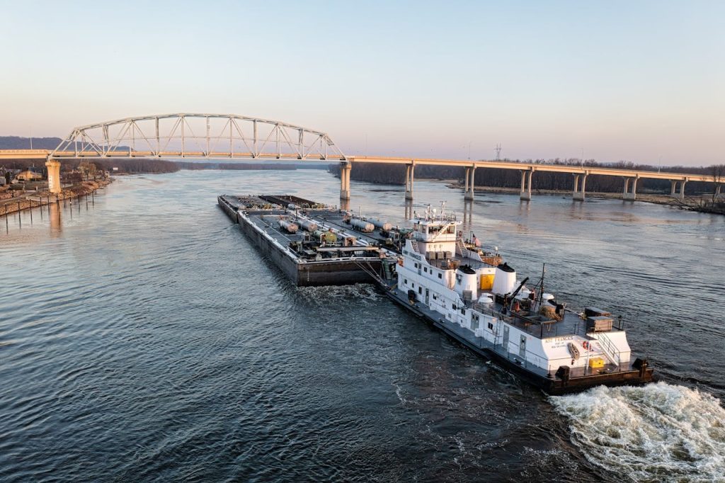Barge Navigating Under Wabasha Bridge at Sunset

