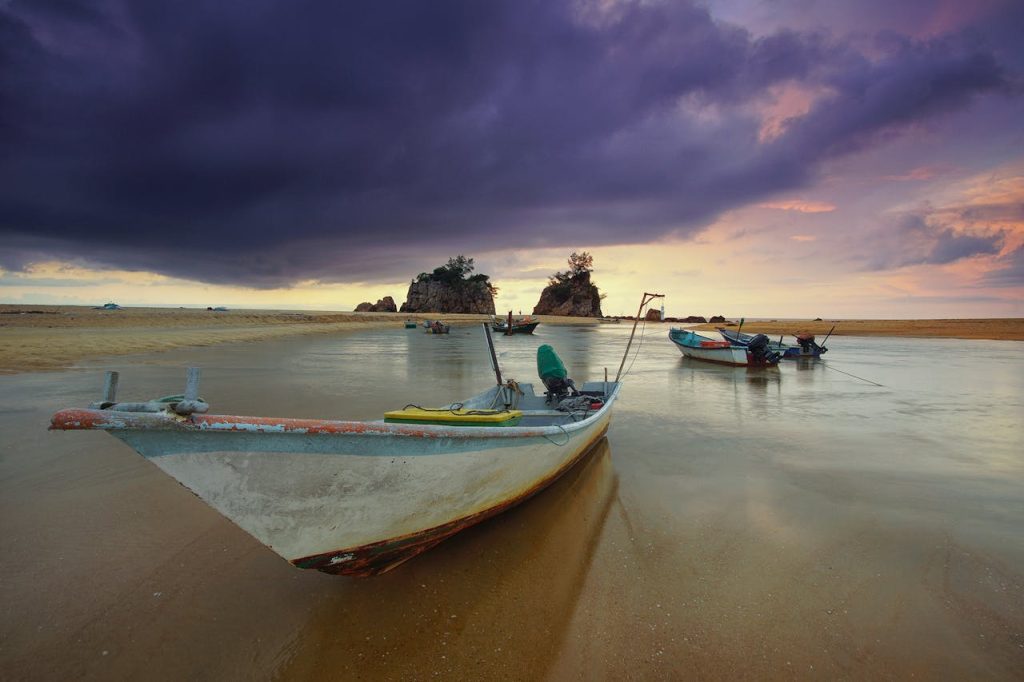 White Boat Park on Seashore Under Gray Sky
