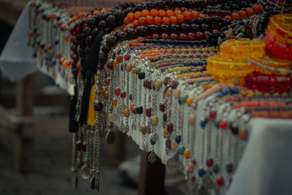 a table of handcrafted ornaments  under string lights