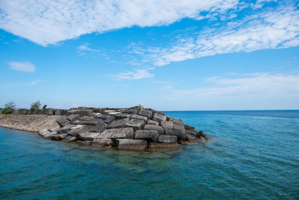 A large rock in the water near the shore
