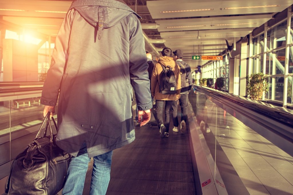 A traveler walking confidently through an airport terminal with soft natural light.