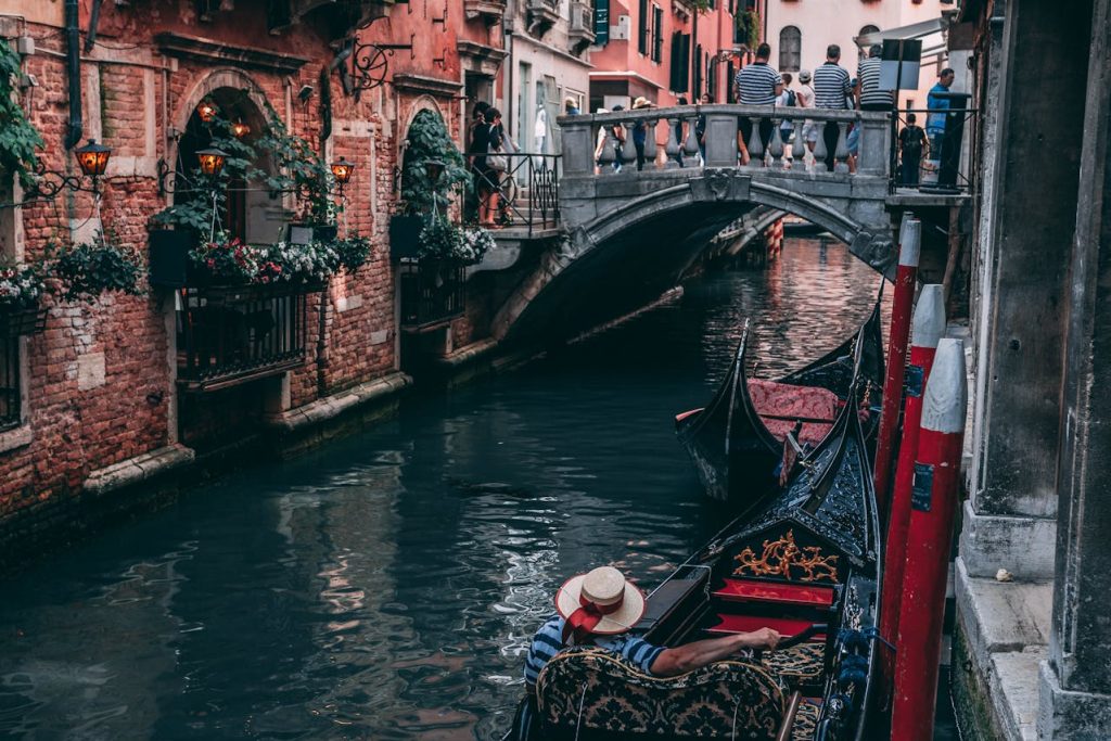 Photo of Man Riding Canoe in Venice, Italy
