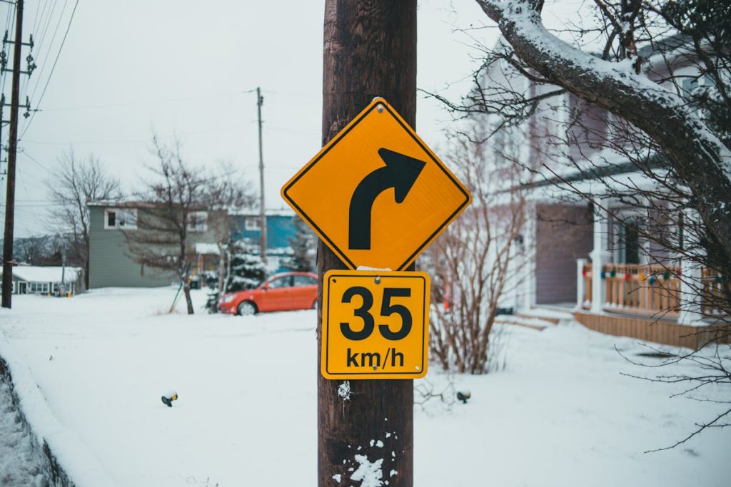 Yellow speed limit and turn signs in winter town