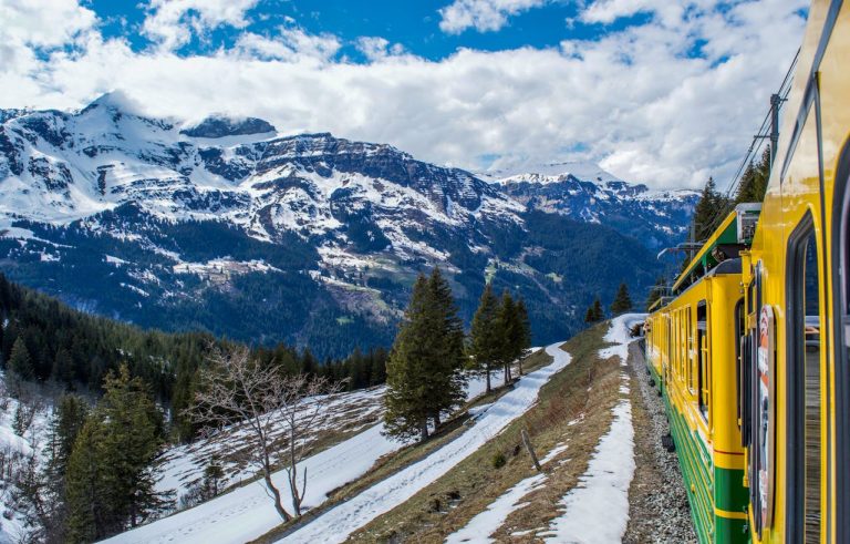 Train riding on railway in mountainous terrain in winter