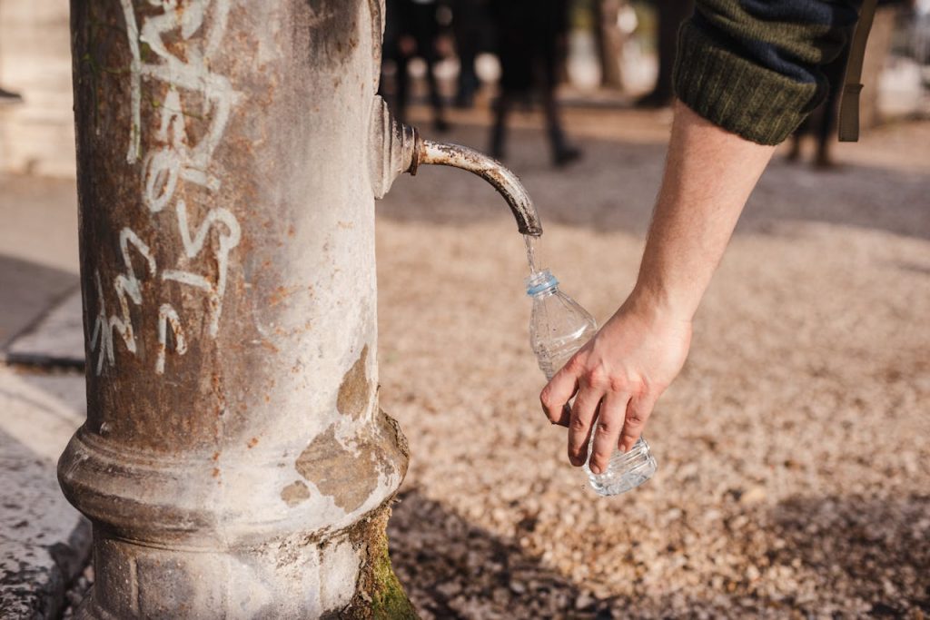 A reusable bottle being filled at a public water station