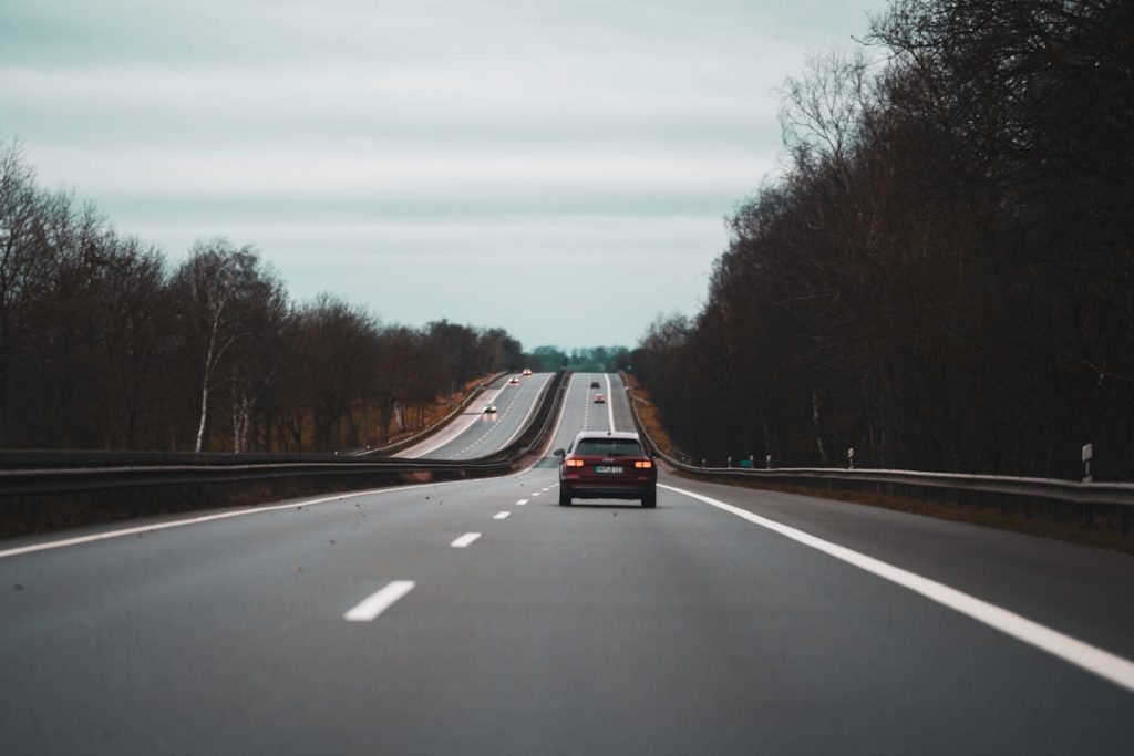 Cars riding on highway in autumn countryside