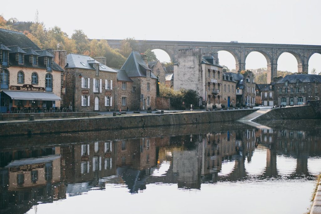 Medieval arched bridge over river in old town on sunny day
