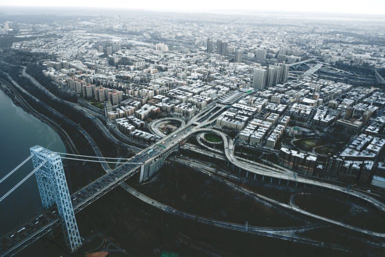 Suspension bridge over river in modern city on overcast day
