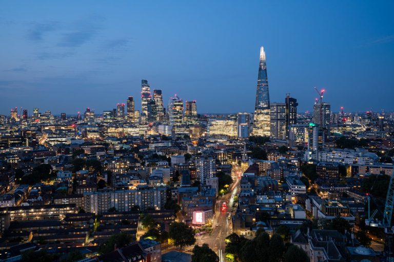 The city of london at night with the shard in the background