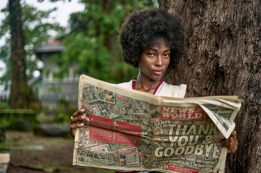 Young Woman Reading Newspaper Outdoors