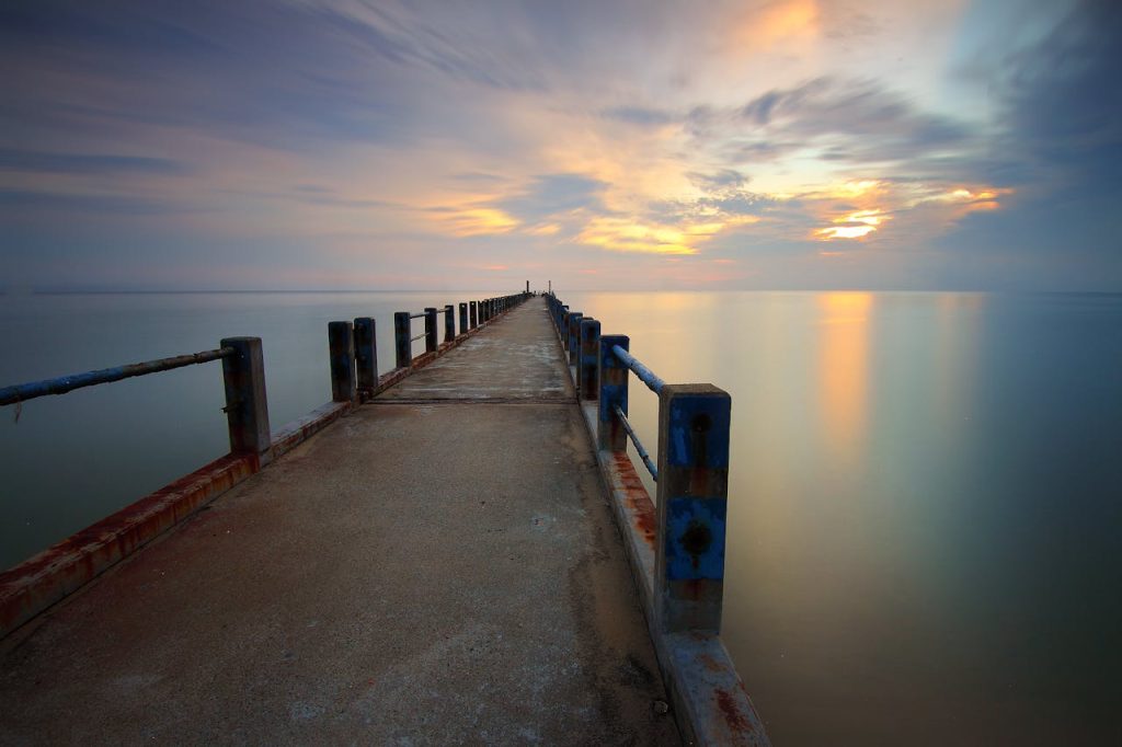 Brown Steel Bridge Beside Large Body of Water