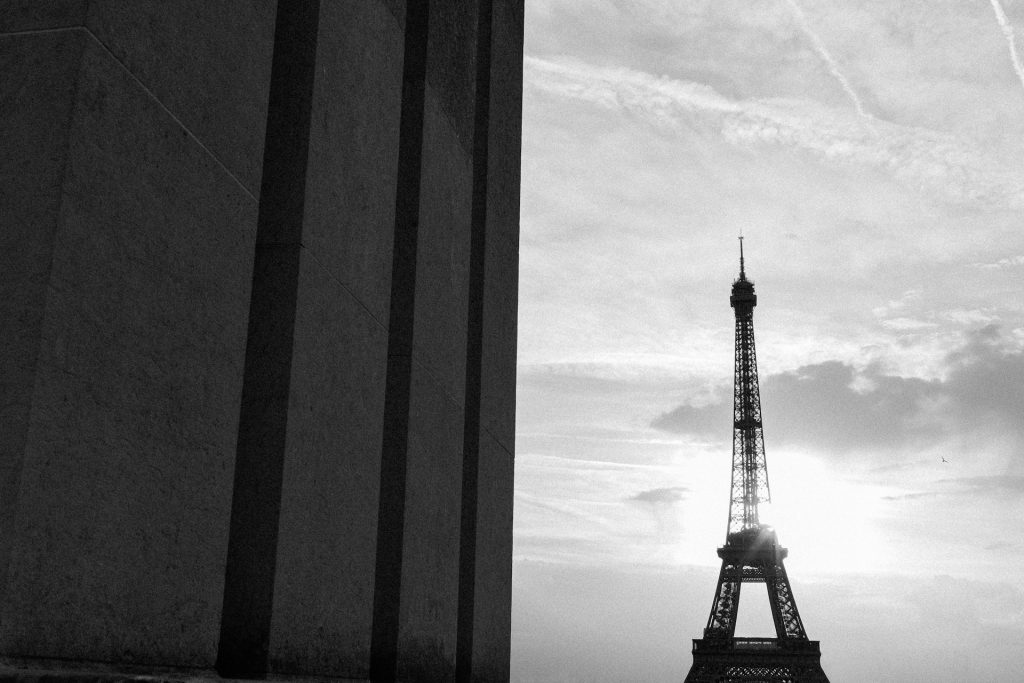 Black and white photograph of the Eiffel Tower and wall.