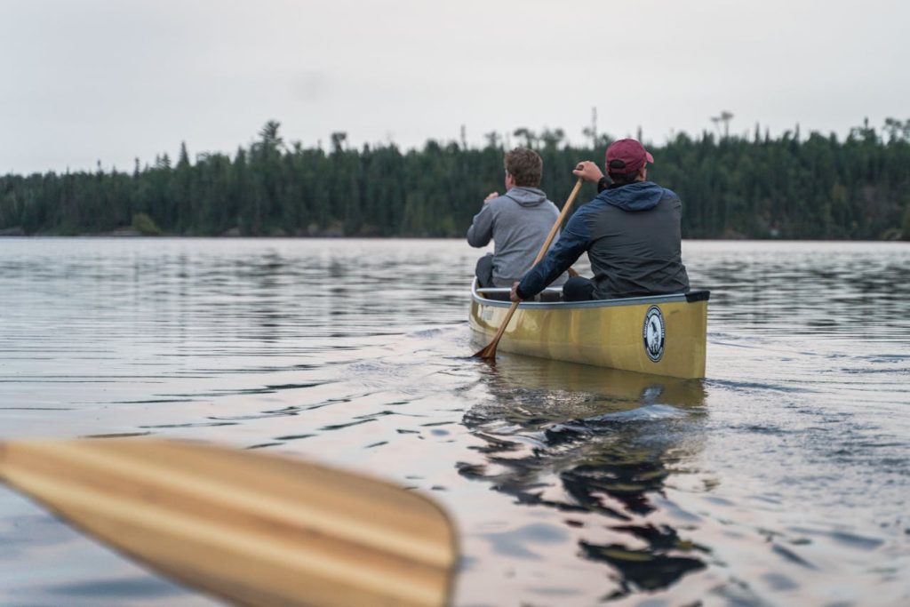 Men Swimming on Kayak in a Lake 
